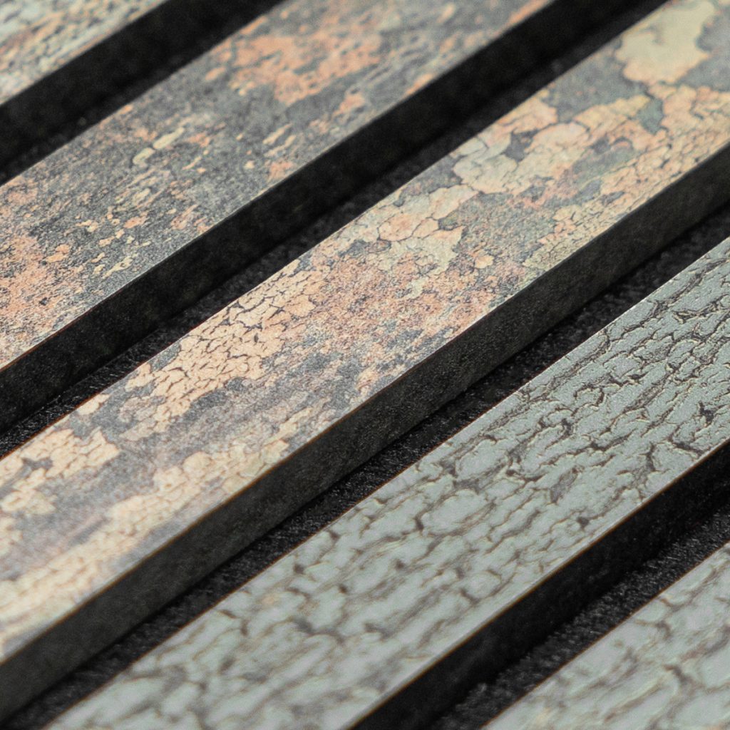 Detalle en primer plano de lamas decorativas de WoodUpp: listones paralelos con acabado craquelado en tonos grises, beige y verdosos, bordes oscuros y ranuras negras entre ellos, mostrando textura rugosa y vetas pronunciadas, ideales para revestimiento o panelado interior acústico.
