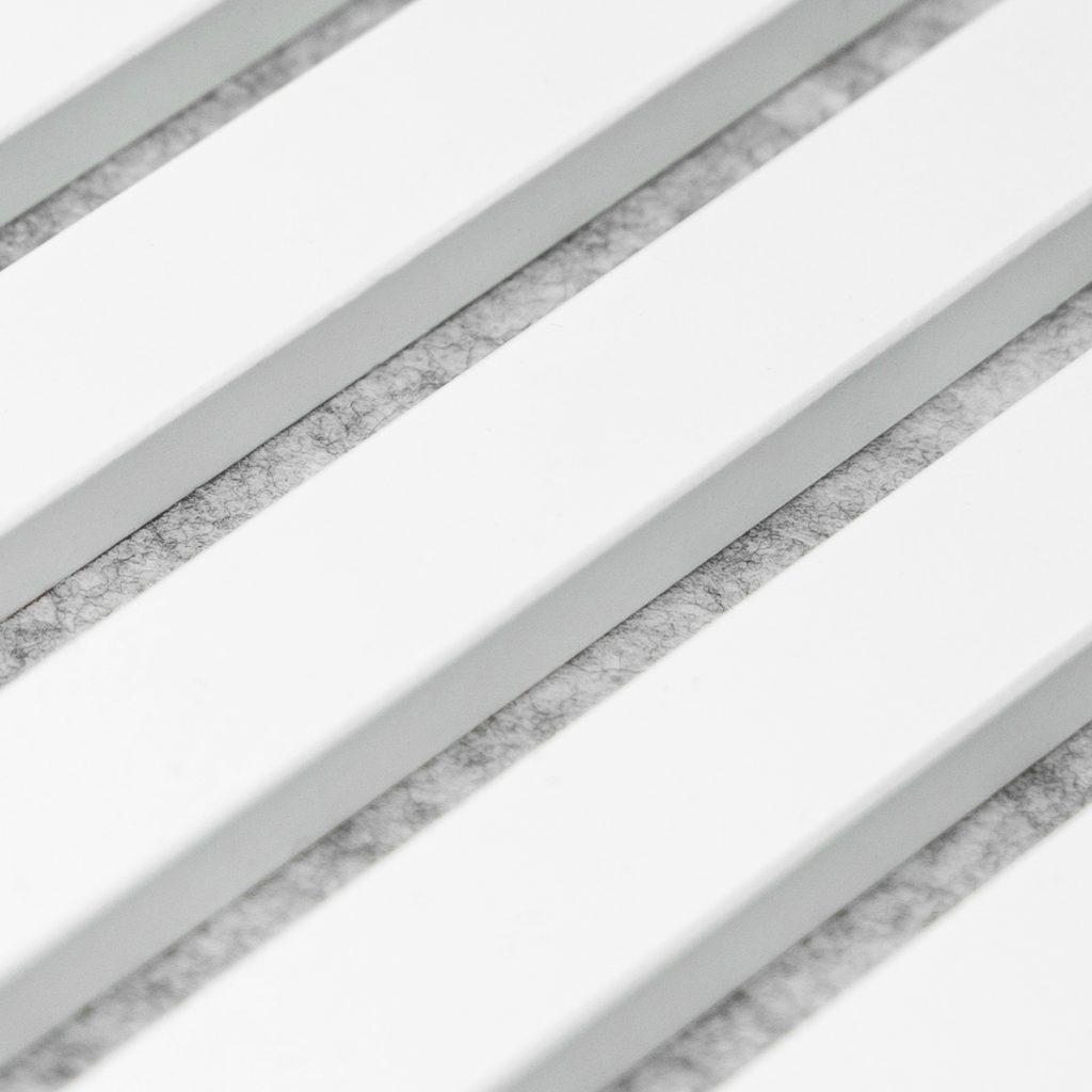 Imagen en primer plano de paneles acústicos de WoodUpp: listones rectangulares blancos en disposición paralela, con ranuras intermedias rellenas por fieltro gris claro para absorción sonora. Acabado liso y corte preciso, aspecto moderno y minimalista, apto para paredes y techos interiores.