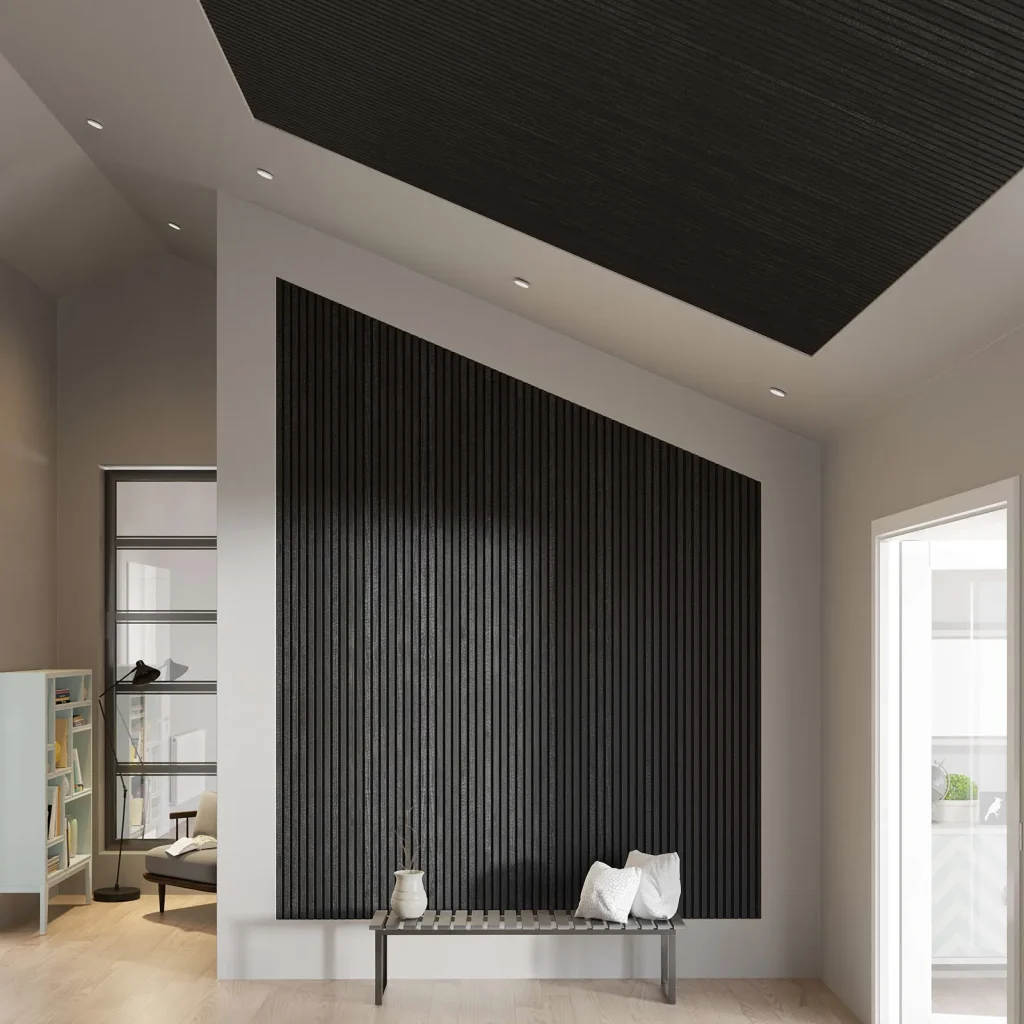 Imagen interior mostrando paneles WoodUpp negros de lamas verticales instalados en pared y techo formando un panel acústico geométrico; banco minimalista frente a la pared con cojines y jarrón. El acabado texturizado y las ranuras regulares resaltan el diseño moderno de los productos WoodUpp.